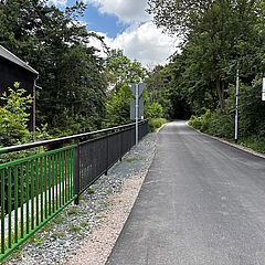 Radweg mit neuem Geländer zum Bach