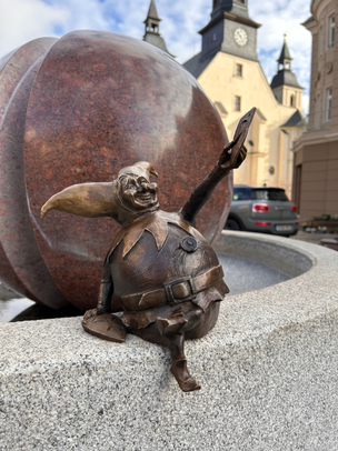 Harlekin mit Maske in der Hand am Postplatzbrunnen