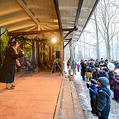 Winterzauber im Stadtpark, viele Kinder lauschen dem Märchenerzähler in der Unterkunftshalle