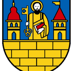 Stadtwappen mit Schutzpatron der Stadt, der heilige Apostel Petrus. Er steht zwischen zwei Türmen und hält in der rechten Hand den goldenen Himmelsschlüssel und in der linken Hand die Bibel. 