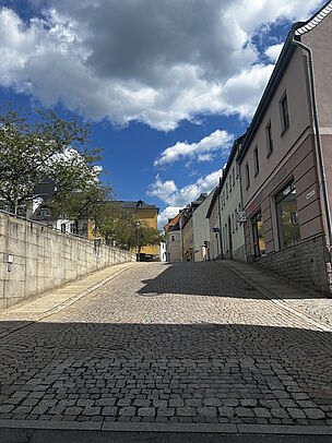 ehemaliges Mylauer Tor mit dunklen Pflastersteinen wurde der Standort des damaligen Mylauer Tors in der Stadtmauer markiert
